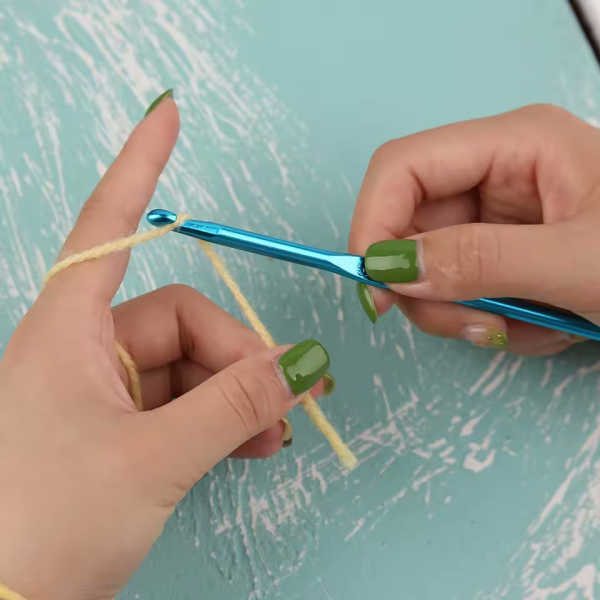 Hands using aluminum crochet hook